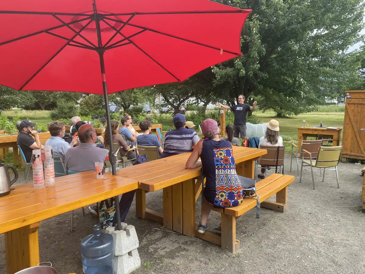 Conférence en plein air à l'ombre d'un parasol rouge